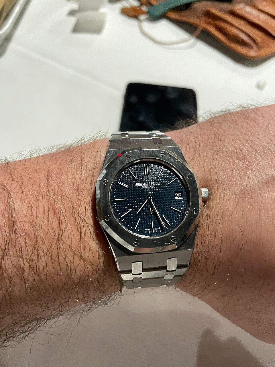 A blue-dial Audemars Piguet Royal Oak with an octagonal bezel and integrated bracelet, worn on a wrist.